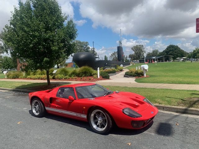Red RF GT40 parked beside a park, front three quarter view